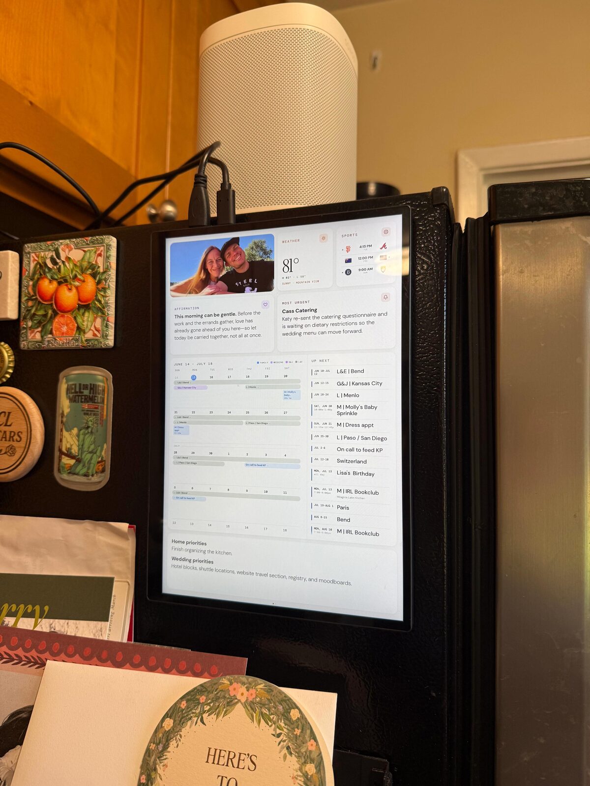A portrait touchscreen mounted on a kitchen cabinet with a HomePod on top, running a Hermes-powered Life Dashboard — a build people actually use.